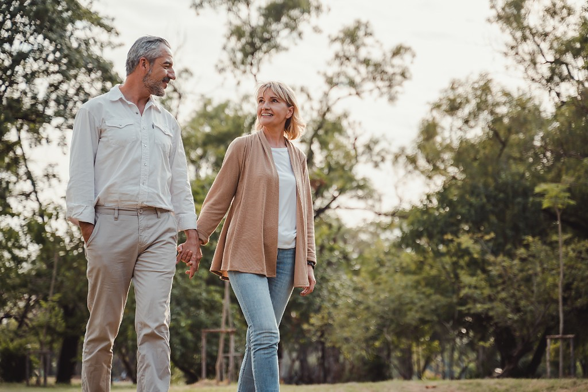 Older couple walking together outdoors after recovery